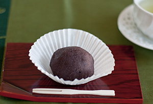 A sesame-seed ohagi cut in half so you can see the anko